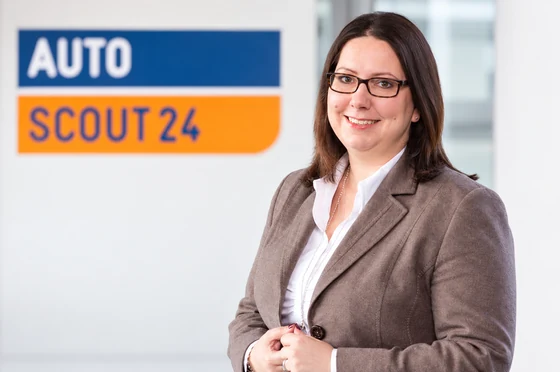 Dr. Katharina Buttenberg wearing a suit in front of the AutoScout24 logo