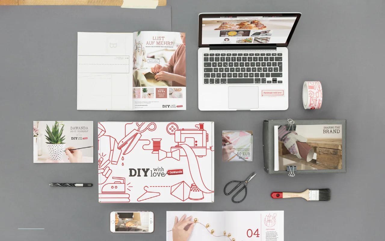 DaWanda DIY brand applications across a laptop, print materials, packaging, vouchers and craft tools.