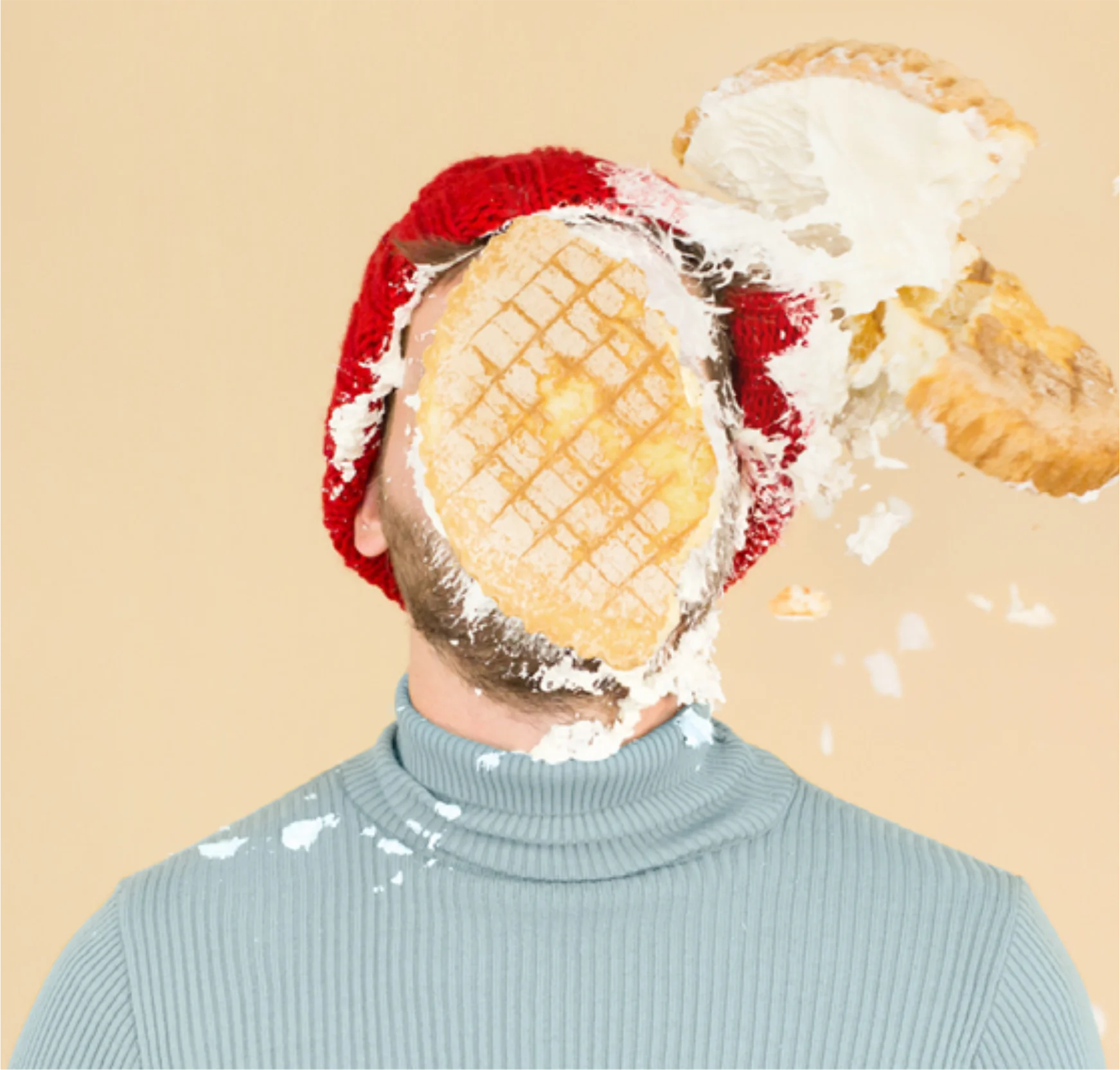 DaWanda creative team portrait with a cream pie and red hat against a pale yellow background.