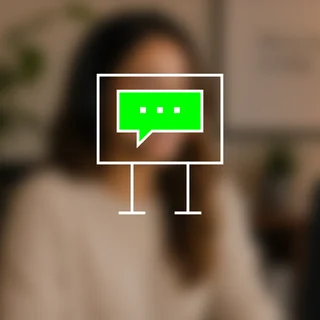 A monitor containing a green chat bubble, over a blurred person.