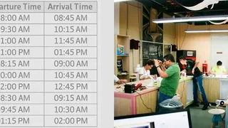 Departure and arrival timetable beside people collaborating in a workshop.